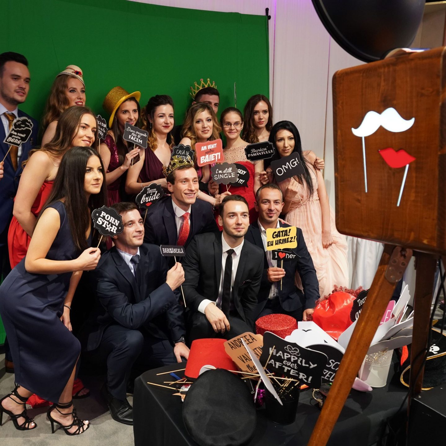 Cabina Foto Vintage Retro & Photo Booth Bucuresti 4 Invitați la nuntă bucurându-se în cabina foto.